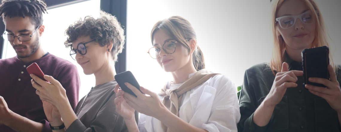 Four young people on mobiles